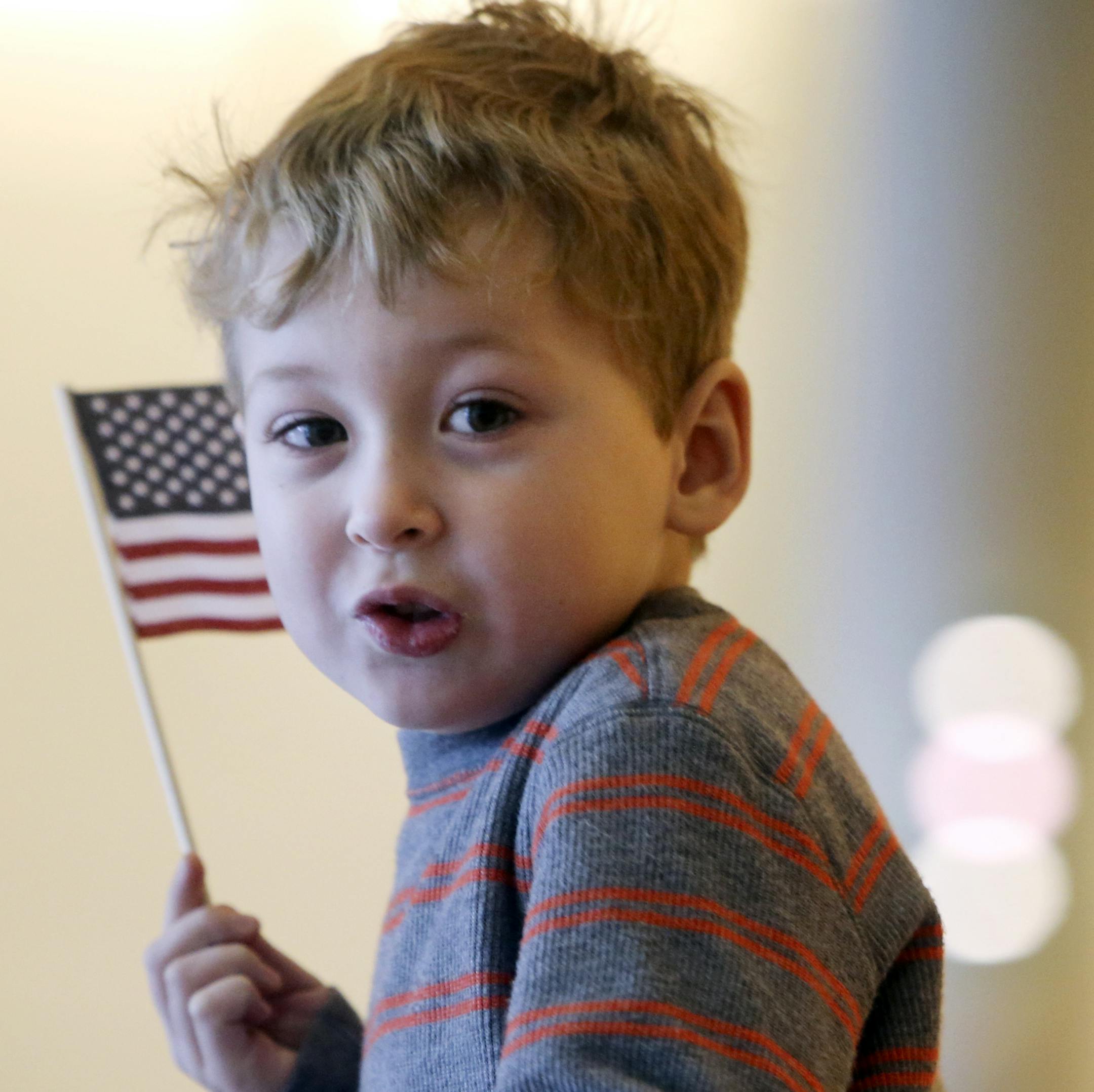 Jovid Gafurov, 5, of Maple Grove, runs with an American flag in the lage hallway of the Minneapolis Convention Center following a Naturalization ceremony for 1,501 immigrants, including his dad Daron Gafurov, comprising hundreds of countries was held Tuesday, Jan. 21, 2014, in Minneapolis, MN. ](DAVID JOLES/STARTRIBUNE) djoles@startribune.com A Naturalization ceremony for 1,501 immigrants comprising hundreds of countries was held at the Minneapolis Convention Center. Following the ceremony, 85 p