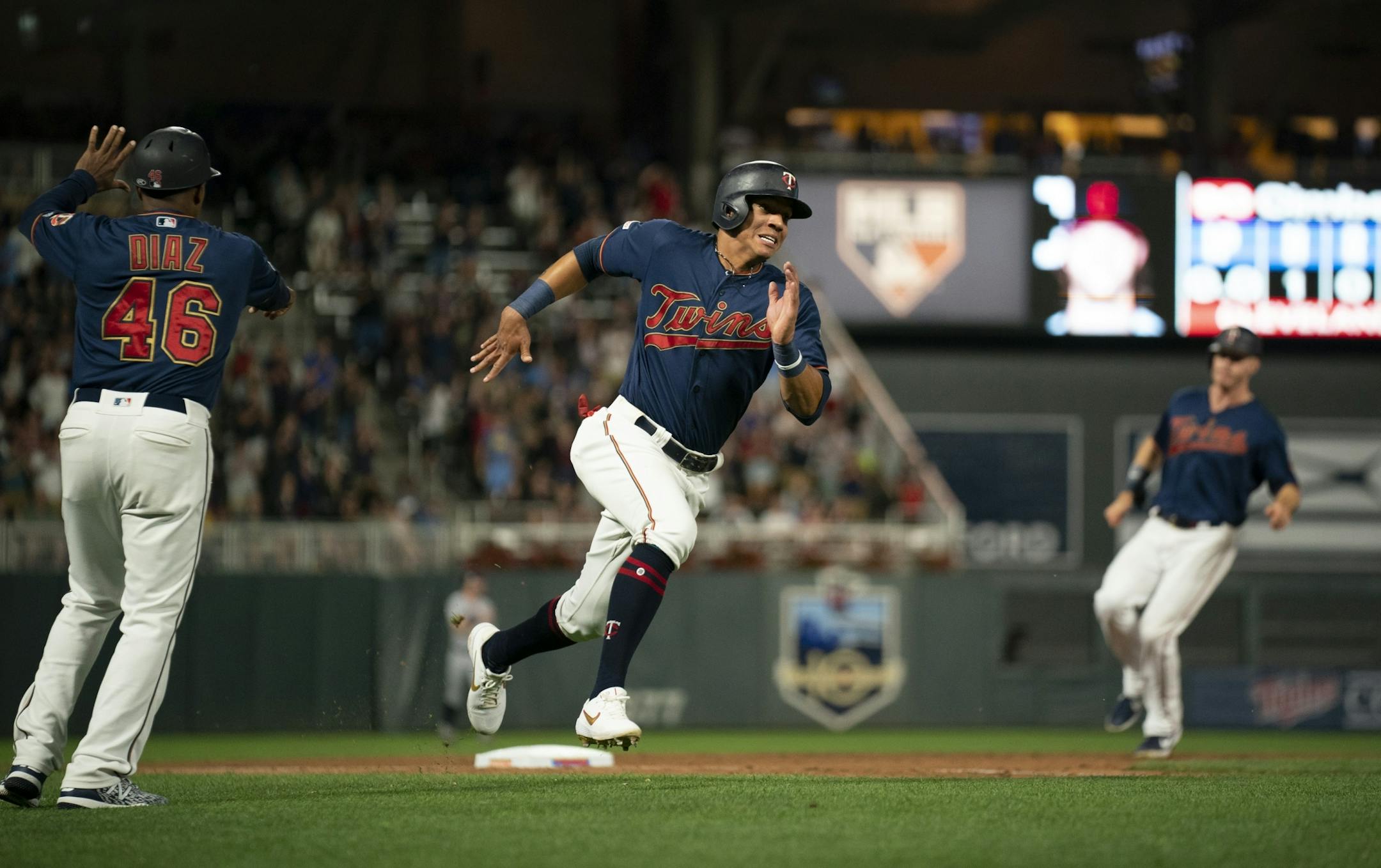 Minnesota Twins first baseman Ehire Adrianza headed for home on a Jorge Polanco double to deep right in the eighth inning while Max Kepler was held at third by Minnesota Twins third base coach Tony Diaz (46).