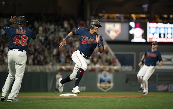 Minnesota Twins first baseman Ehire Adrianza headed for home on a Jorge Polanco double to deep right in the eighth inning while Max Kepler was held at