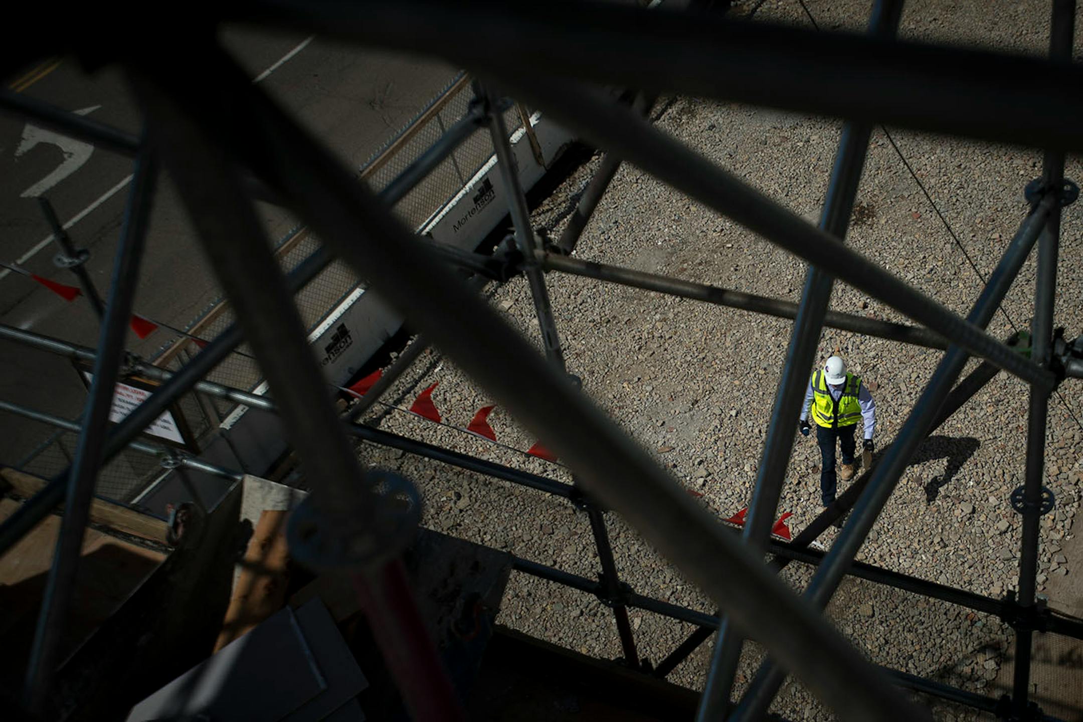 A Mortenson Construction employee walks along the perimeter of the new Senate Office Building construction site on Tuesday afternoon.