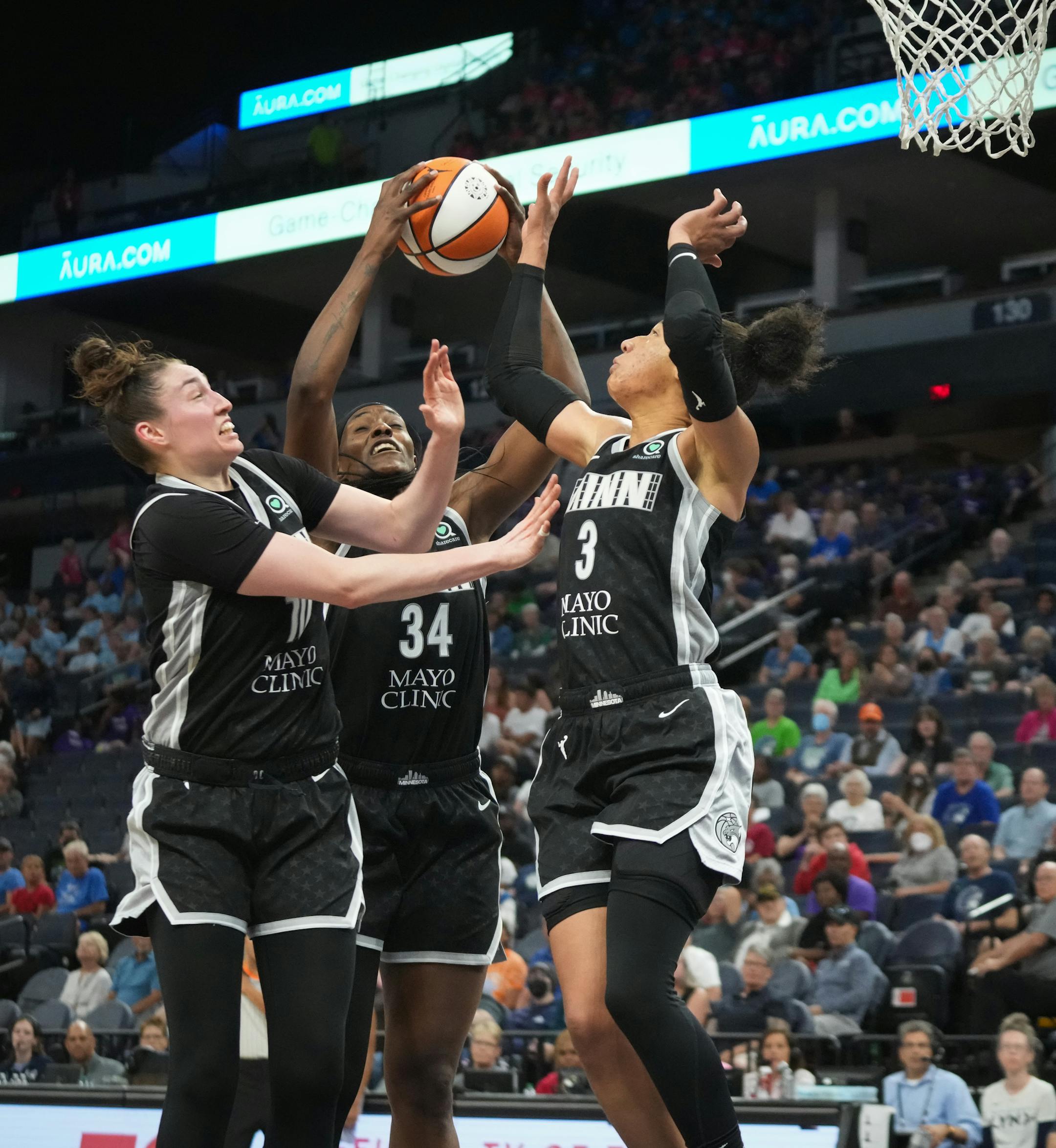 Minnesota Lynx players Jessica Shepard (10), Sylvia Fowles (34), and Aerial Powers (3) all collapse for a rebound in the second half.