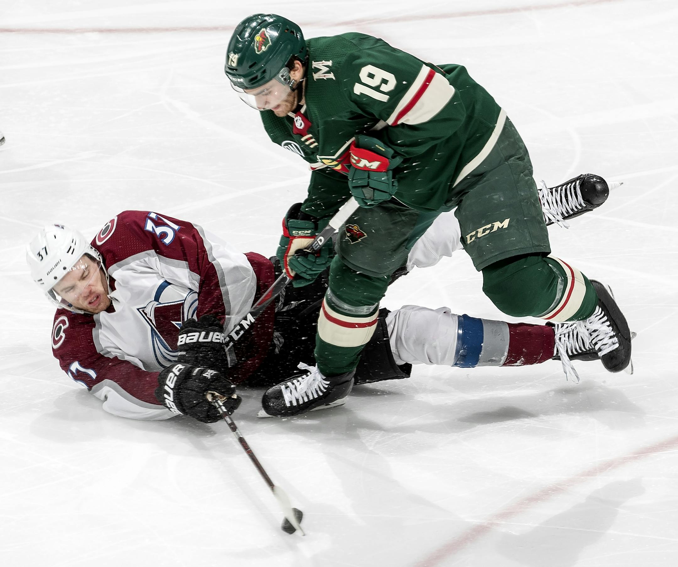 J.T. Compher (37) and Luke Kunin (19) fought for the puck in the third period.