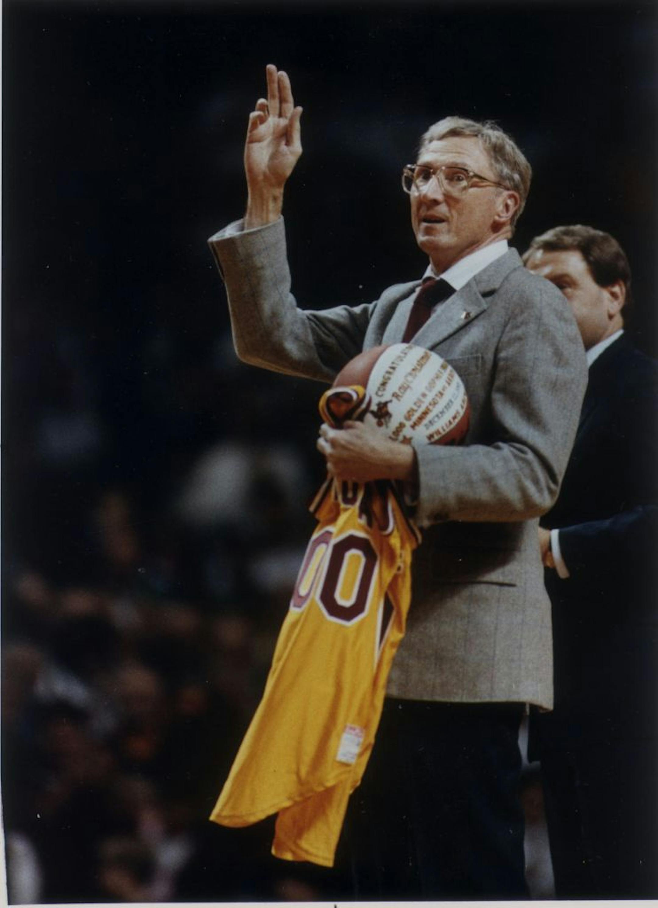 Radio broadcaster Ray Christensen waves to the crowd during half time of a Gophers basketball game 12/11/91. Christensen was honored for his 1,000 college broadcast.