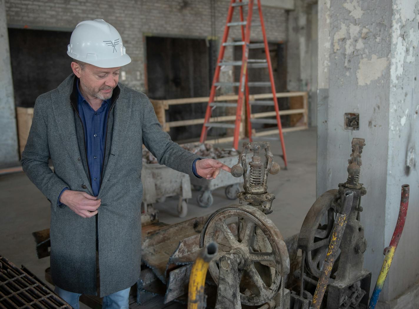 Brian Whiting, President of Telos shows off an old pulley from the elevator during a tour of the Old Post Office, 433 W. Van Buren Street, Tuesday, March 12, 2019 in Chicago, IL. Photo by Rob Hart