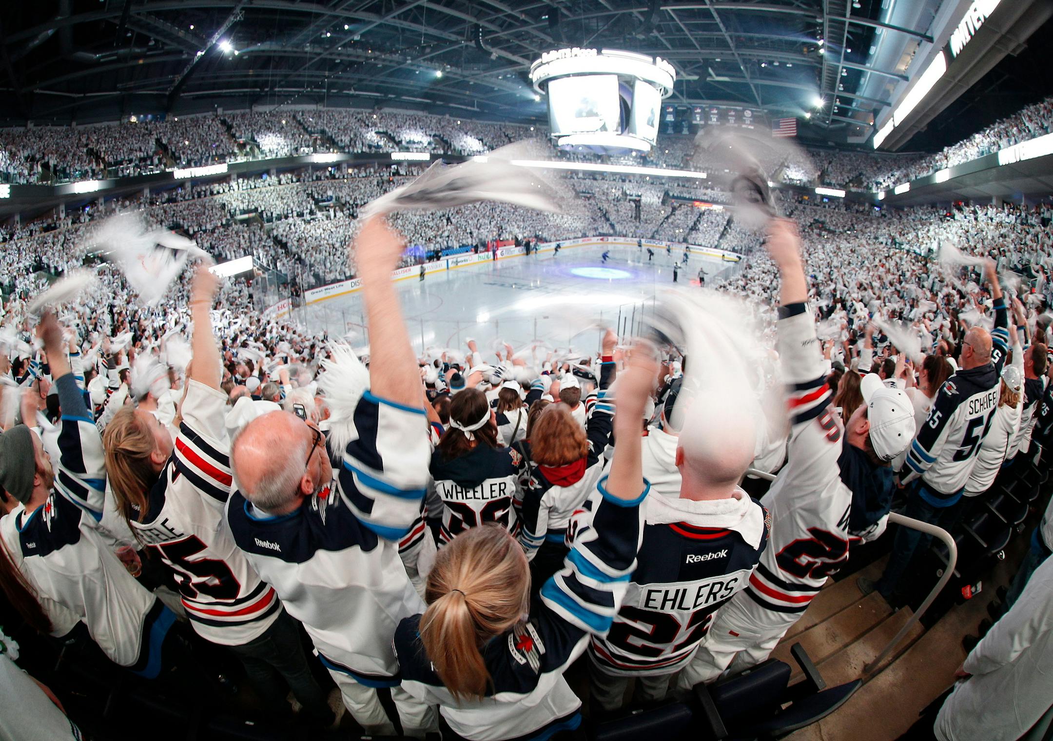Winnipeg Jets fans cheer on the team as players hit the ice before Game 1 in an NHL hockey first-round playoff series against the Minnesota Wild, Wednesday, April 11, 2018, in Winnipeg, Manitoba. (John Woods/The Canadian Press via AP)