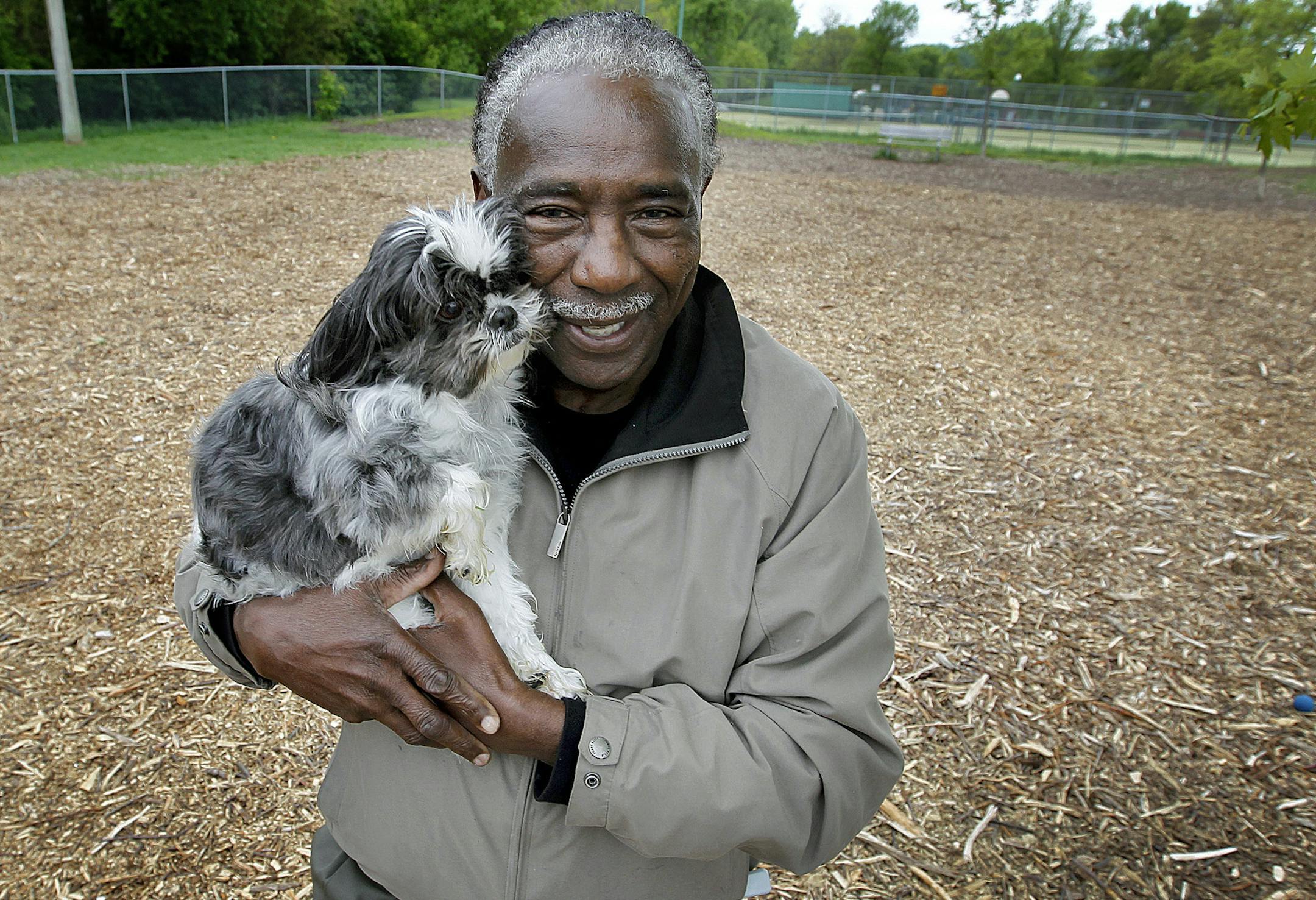 Isaac Ward cuddled with "Baby" at Bassett Creek Dog Park, Tuesday, May 28, 2013 in Crystal, MN. Ward brought suit to the Bloomington Police after he was beaten in 2009 after an assault that was triggered by a dispute with an animal control officer at a dog park in Bloomington. (ELIZABETH FLORES/STAR TRIBUNE) ELIZABETH FLORES • eflores@startribune.com