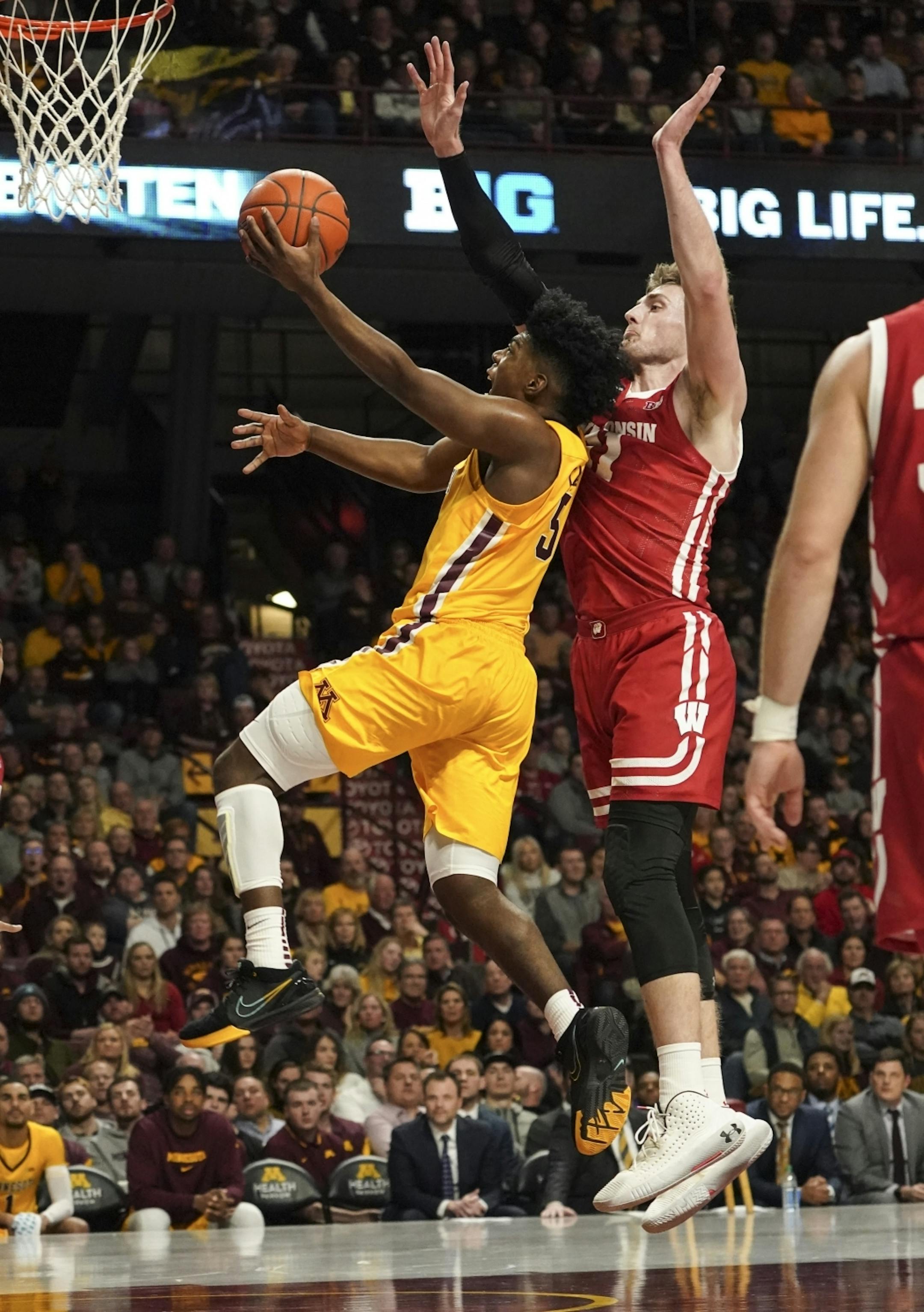 Minnesota Gophers guard Marcus Carr (5) jumped for a shot against Wisconsin Badgers forward Micah Potter (11) in the second half. A foul was called on Wisconsin.