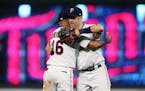 Minnesota Twins' Joe Mauer, right, and Ehire Adrianza celebrate the Twins 10-5 win over the New York Yankees in a baseball game Tuesday, Sept. 11, 201