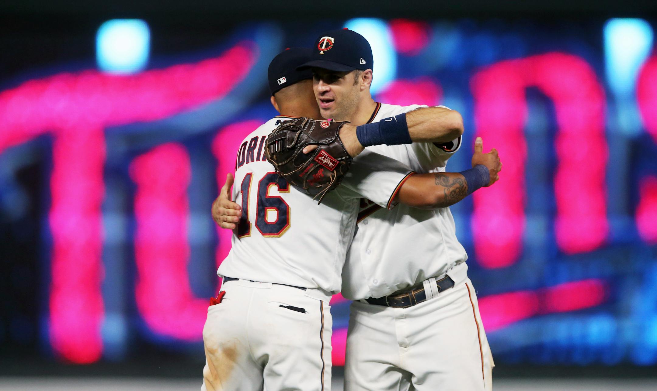 Minnesota Twins' Joe Mauer, right, and Ehire Adrianza celebrate the Twins 10-5 win over the New York Yankees in a baseball game Tuesday, Sept. 11, 2018, in Minneapolis. Mauer hit a grand slam in the fifth inning. (AP Photo/Jim Mone)