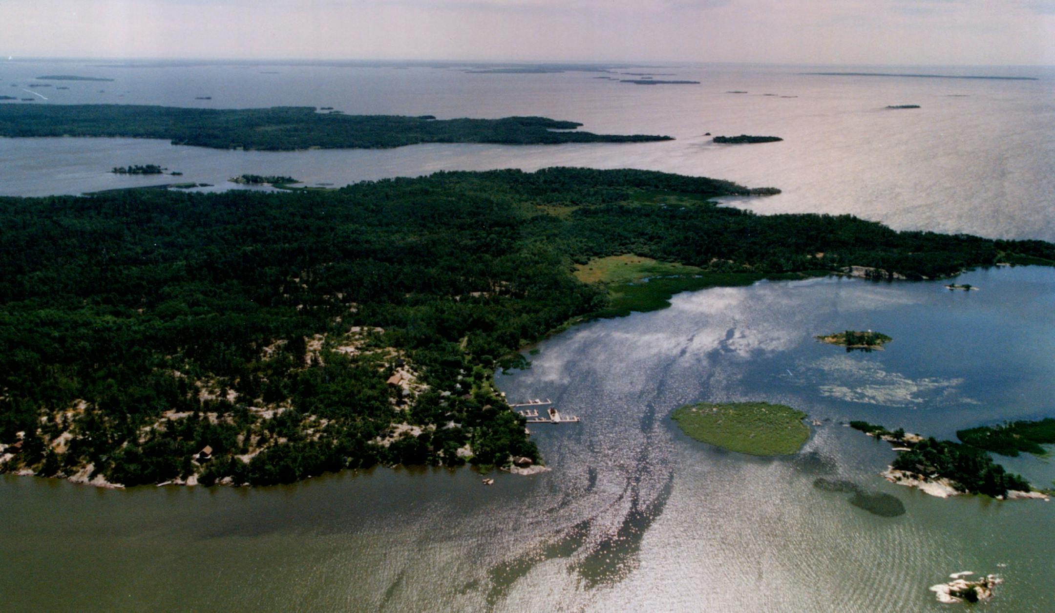 August 20, 1993 Aerial view - 14,000 islands in Lake of the Woods, 'we' think this is Oak Island, on which a third of the counties resorts are located. There are more than 14,000 islands in Lake of the Woods, which straddles the border between Minnesota and Canada. Where there's more than walleye to hook tourists Lake of the Woods County, Minn. Near the northernmost tip of the continental United States, Don McClanathan looked from his Lake of the Woods resort toward a nesting tree on a point of
