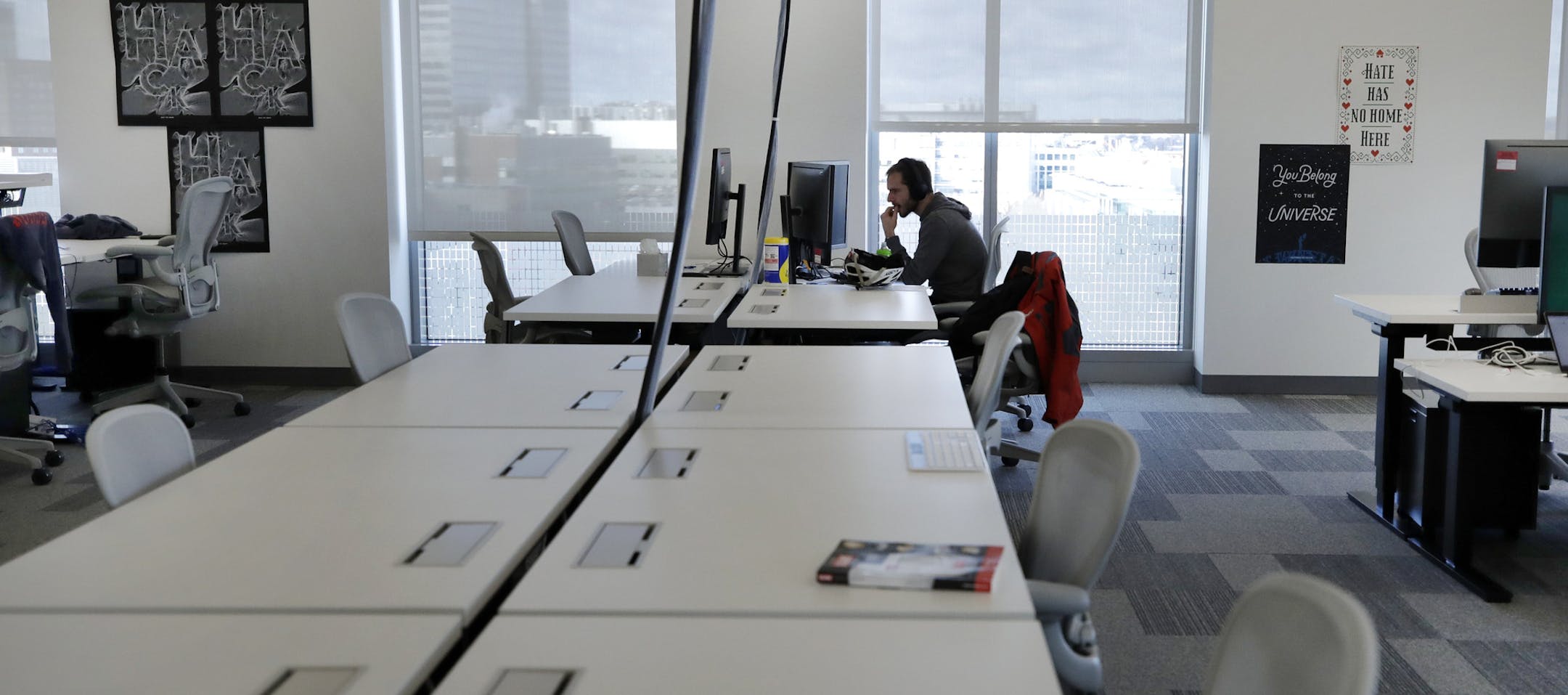 In this Jan. 9, 2019 photo, Facebook employees are seen at their stations during a tour of its new 130,000-square-foot offices, which occupy the top three floors of a 10-story Cambridge, Mass. building. The space gives the company room to triple its current local staff of more than 200. The Silicon Valley company, created by Mark Zuckerberg when he was two subway stops away at Harvard University, opened its first Boston office five years ago. (AP Photo/Elise Amendola)