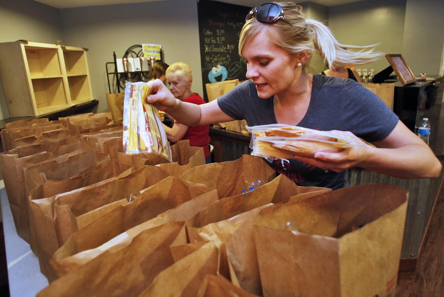 Volunteer Katrina Thai places food items in grocery bags for distribution to the needy. ] The Summer Loaves program at Christ Church in Apple Valley provides free lunches to parents and their children as well as providing other food supplies, clothing, books and games. (MARLIN LEVISON/STARTRIBUNE(mlevison@startribune.com)