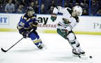 Minnesota Wild's Jason Zucker, right, controls the puck as St. Louis Blues's Kevin Shattenkirk pursues during the first period of an NHL hockey game T