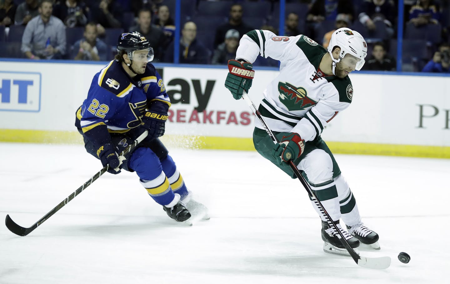 Minnesota Wild's Jason Zucker, right, controls the puck as St. Louis Blues's Kevin Shattenkirk pursues during the first period of an NHL hockey game Thursday, Oct. 13, 2016, in St. Louis. (AP Photo/Jeff Roberson)