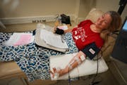 Kathryn Kottke graded honors English papers while donating platelets Saturday at Memorial Blood Center in Eden Prairie.