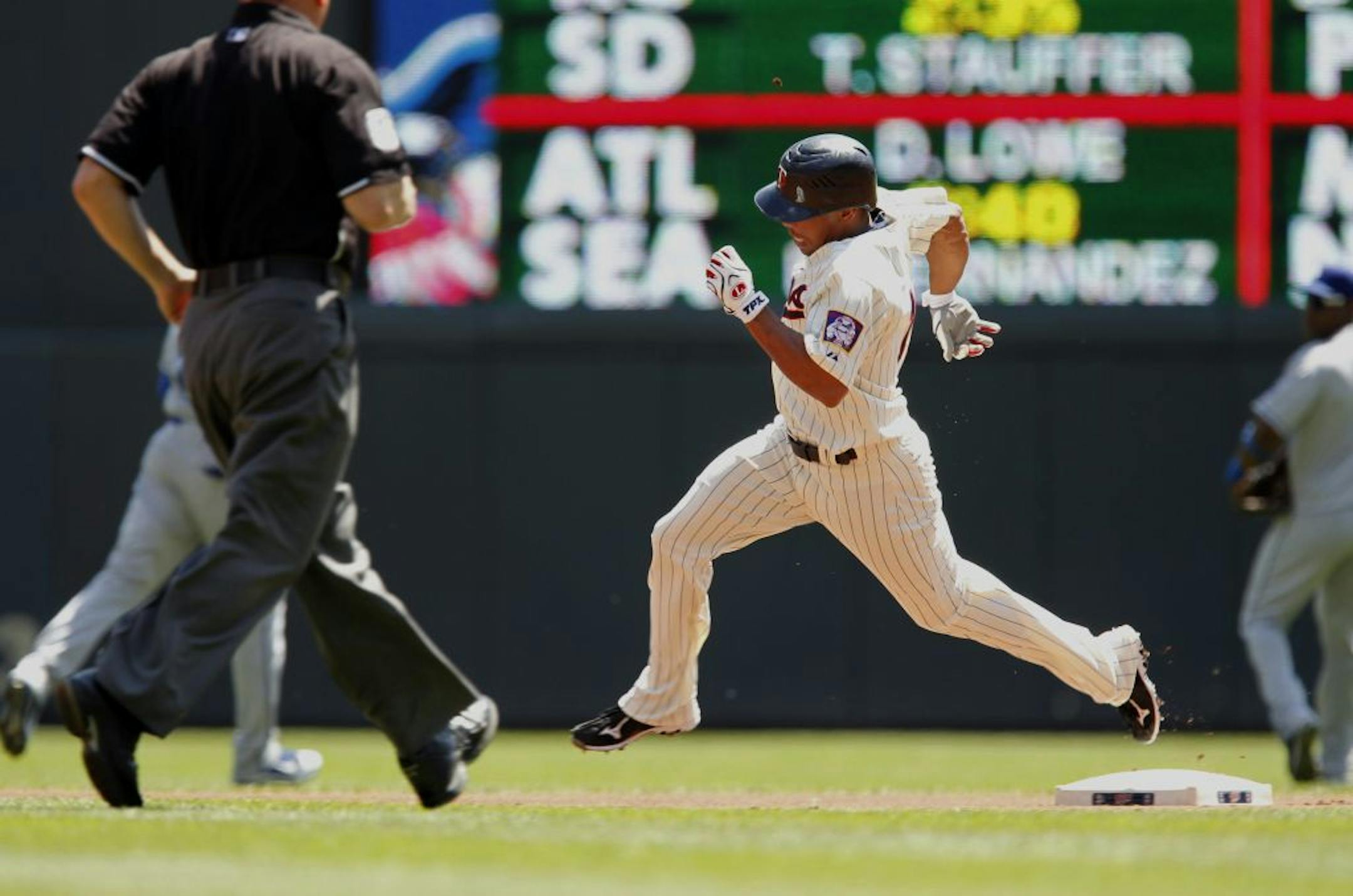 Minnesota Twins' Ben Revere rounds second base with a lead-off triple against the Los Angeles Dodgers during the first inning of an interleague baseball game, Wednesday, June 29, 2011, in Minneapolis.