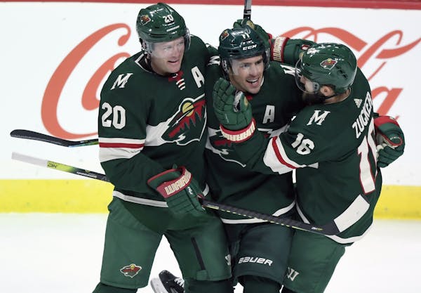 Minnesota Wild's Ryan Suter (20) and Jason Zucker (16) congratulate left wing Zach Parise (11) on his goal against the Arizona Coyotes during the thir