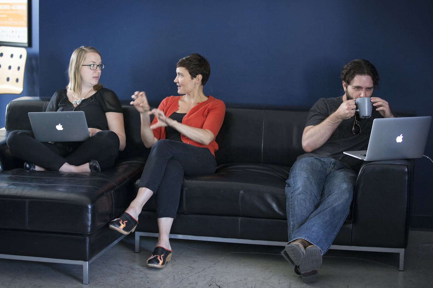 Project manager Meghan "Megs" Gencev, from left, talks with user experience architect Laura Horan as front end developer Adam Schmid works at right in a communal area at the Clockwork office in Minneapolis. ] (Leila Navidi/Star Tribune) leila.navidi@startribune.com BACKGROUND INFORMATION: Tuesday, June 7, 2016 in Minneapolis. Clockwork Active Media once again topped the Top Workplaces list for small businesses.