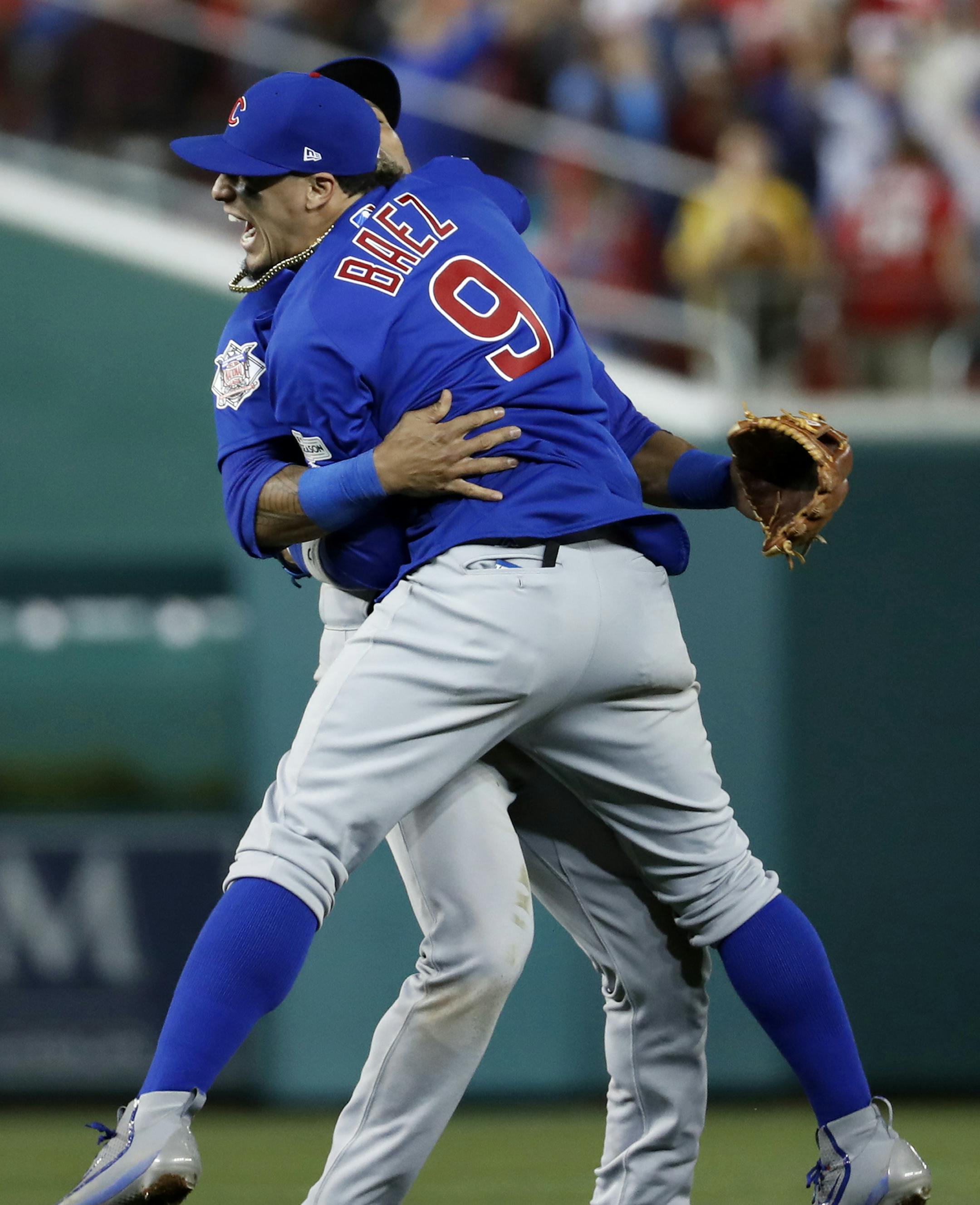 Chicago Cubs' Javier Baez (9)m, right, celebrates with teammate Addison Russell after beating the Washington Nationals 9-8 to to win baseball's National League Division Series, at Nationals Park, early Friday, Oct. 13, 2017, in Washington. (AP Photo/Alex Brandon)