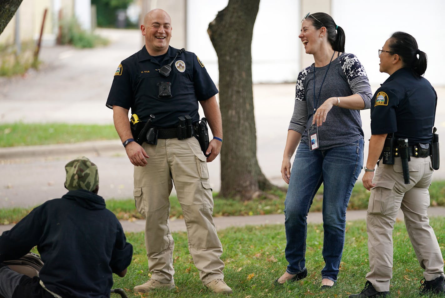 Licensed clinical social worker Kara Haroldson, center, stood with officers Justin Tiffany and Lori Goulet as they checked the well being of a man sleeping in a park.] ANTHONY SOUFFLE &#x2022; anthony.souffle@startribune.com A pair of social workers from Regions Hospital worked alongside St. Paul police responding to mental health crisis calls Sept. 13, 2018 in St. Paul.