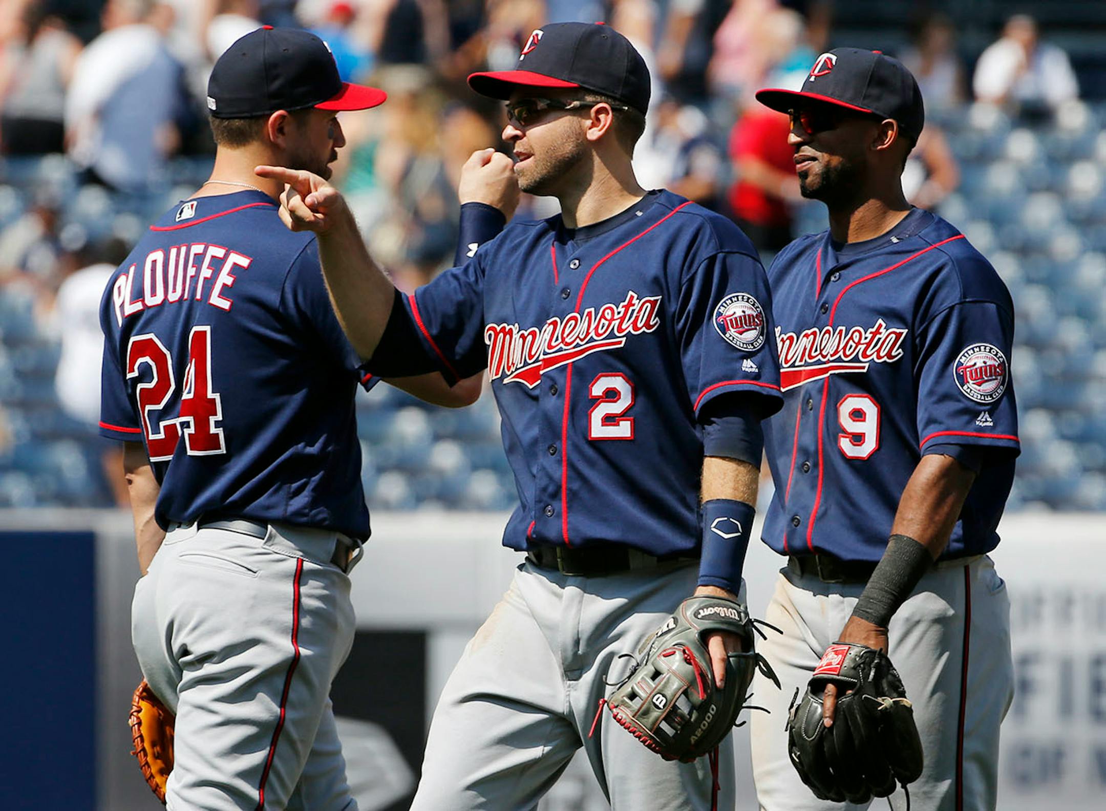 Minnesota Twins first baseman Trevor Plouffe (24), second baseman Brian Dozier (2) and third baseman Eduardo Nunez (9) celebrate after the Twins defeated the New York Yankees 7-1 in a baseball game in New York, Sunday, June 26, 2016.