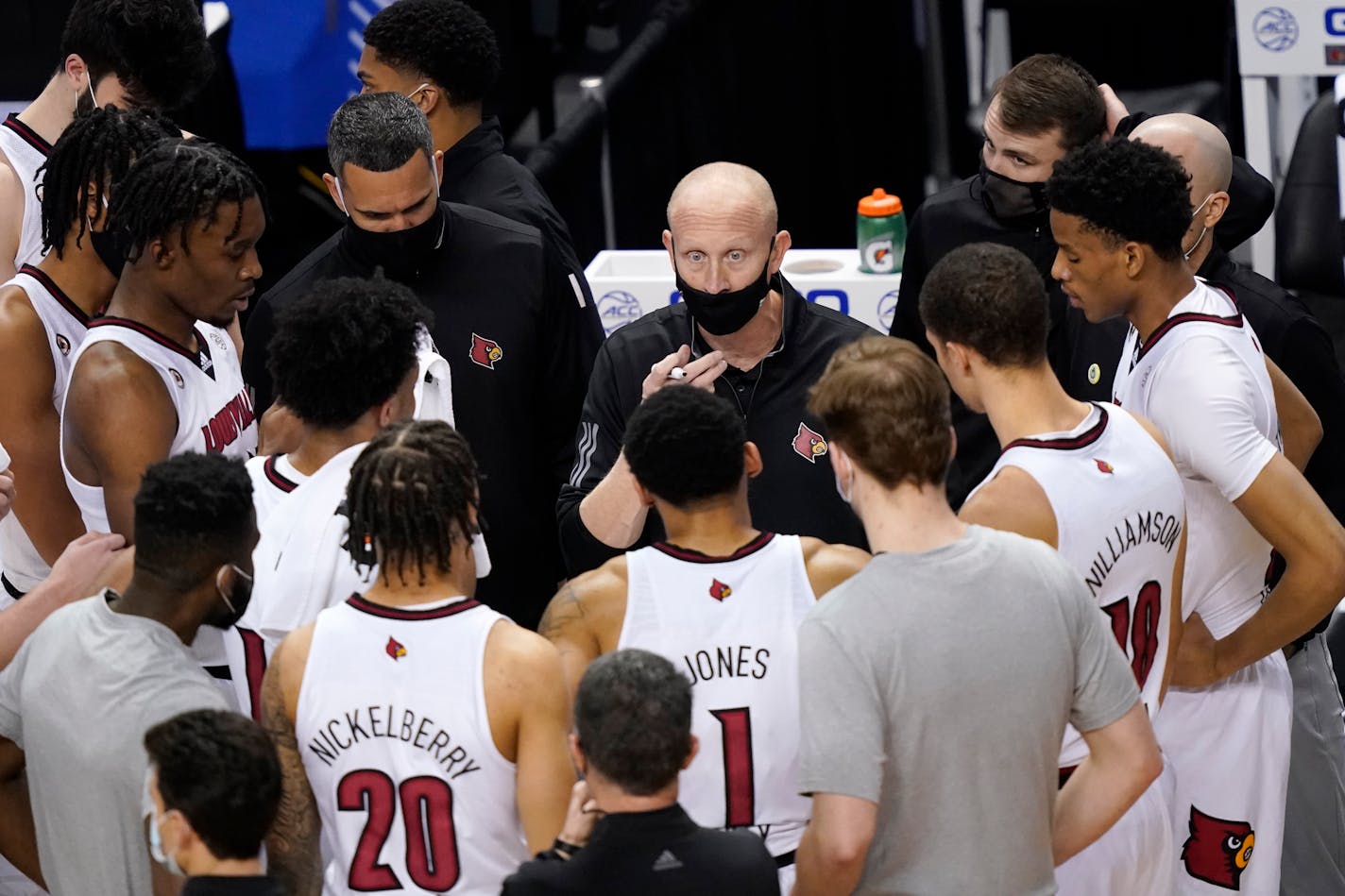 Louisville coach Chris Mack, center, talks with his team during the first half against Duke in the second round of the Atlantic Coast Conference tournament