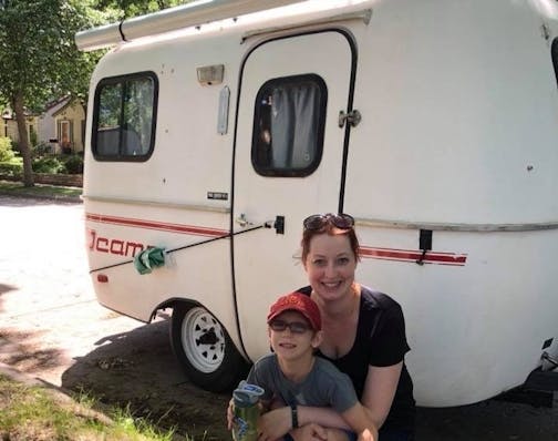 photo of woman and child with camper