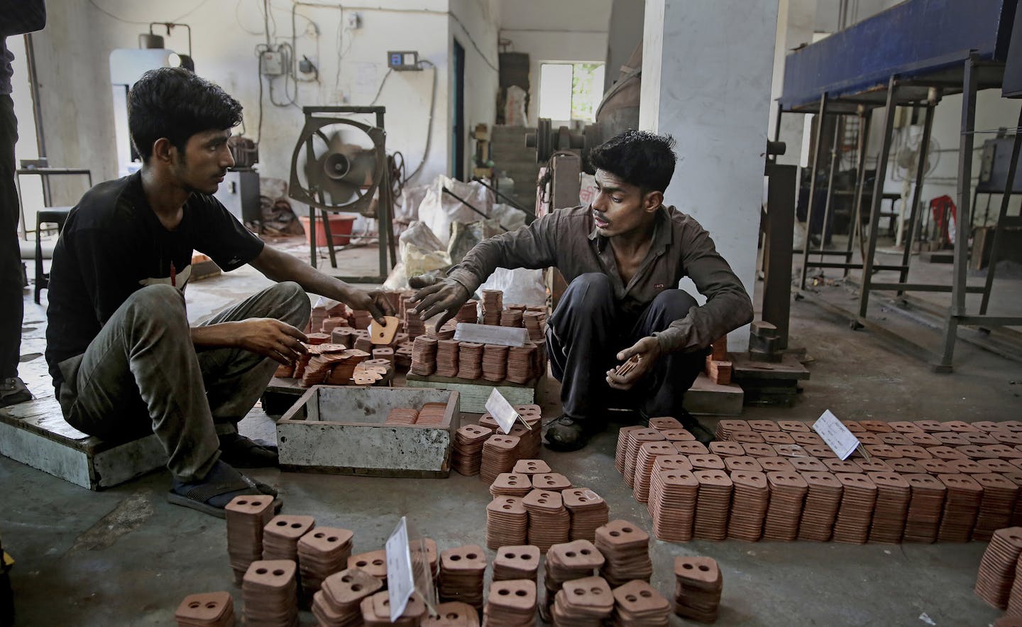 FILE - In this Sept. 5, 2019, file photo, Indian workers prepare packing of clutch buttons at an auto component manufacturing factory on the outskirts of New Delhi, India. Asian shares advanced Friday, Sept. 20, 2019, and India&#x2019;s benchmark jumped 5.4% after the government announced plans to cut corporate taxes. (AP Photo/Altaf Qadri, File)