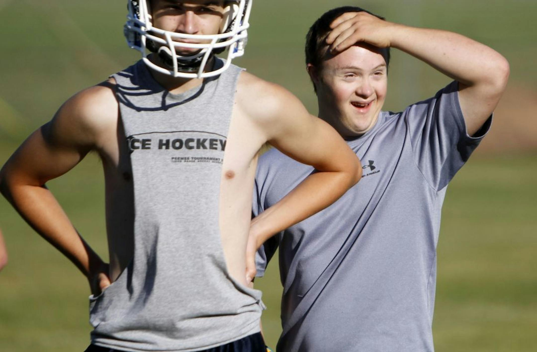 FILE - In this Aug. 6, 2012 file photo, 19-year-old Eric Dompierre, right, who has Down syndrome and is the kicker for the Ishpeming High School varsity football team, arrives on the field for the first day of practice at the Ishpeming Playgrounds in Ishpeming, Mich.