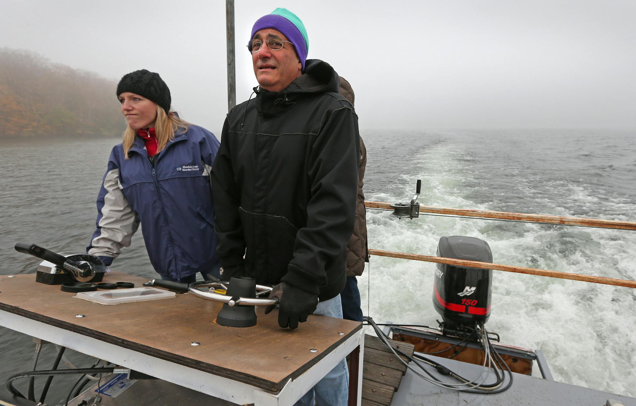 (left to right) Renae Clark, Minnehaha Creek Watershed District Project Manager and Gabriel Jabbour, owner of Tonka Bay Marina, drove a construction barge out to Big Island in Lake Minnetonka where shore restoration is under construction on 10/31/13. Along the shores of Big Island in Lake Minnetonka, bluffs are collapsing and trees have fallen into the water. The problem is erosion caused by too many waves, including those produced by boats in the popular Cruiser's Cove area nearby. The Minnehah
