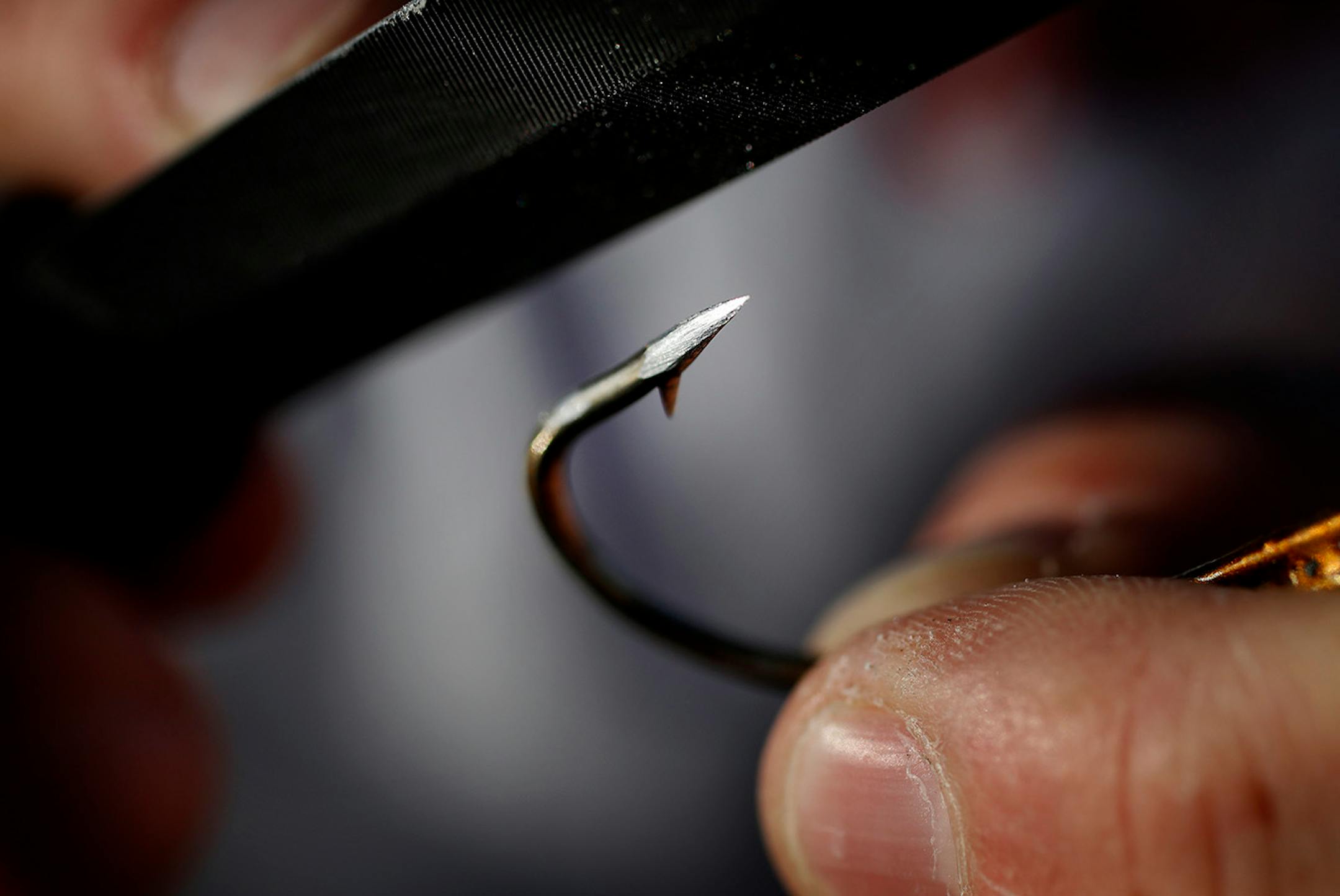 Fishing guide Travis Frank sharpened the hooks on a lure. Frank sharpens his hooks every time before he fishes for Muskie.