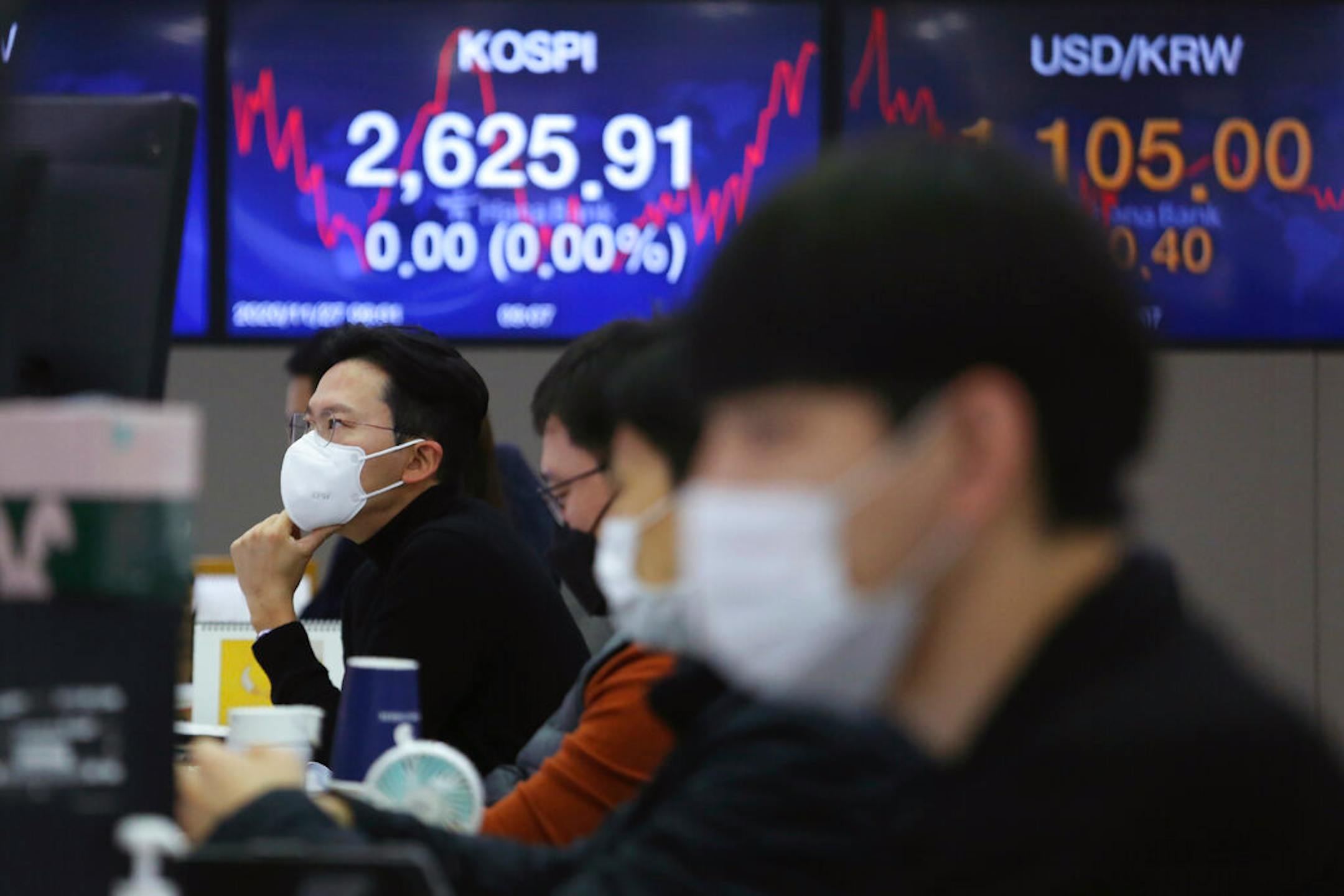 A currency trader watches monitors at the foreign exchange dealing room of the KEB Hana Bank headquarters in Seoul, South Korea, Friday, Nov. 27, 2020.