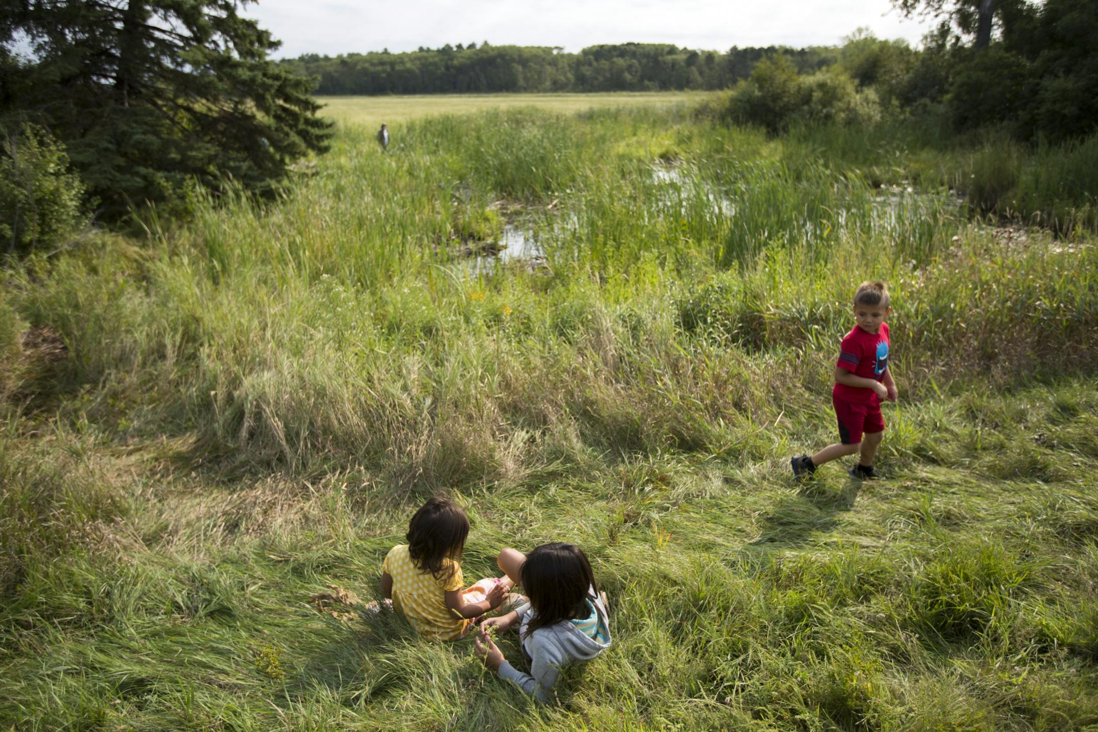 Children play at the edge of Hole In The Day Lake where their parents prepared to harvest wild rice on Thursday morning.