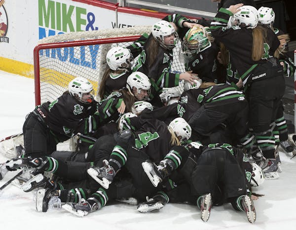 Hill-Murray players pile on top one another while celebrating their 2-1 victory over Minnetonka in the Class 2A Girls' Hockey Championship game. ] (Aa