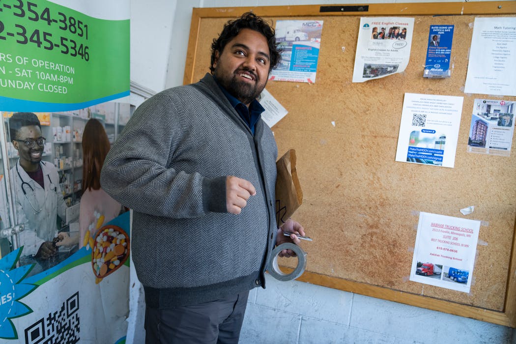 Murid Amini checks inside a Cedar-Riverside neighborhood market in Minneapolis to see if a flyer for MOOV, his new rideshare business, is still on a board.