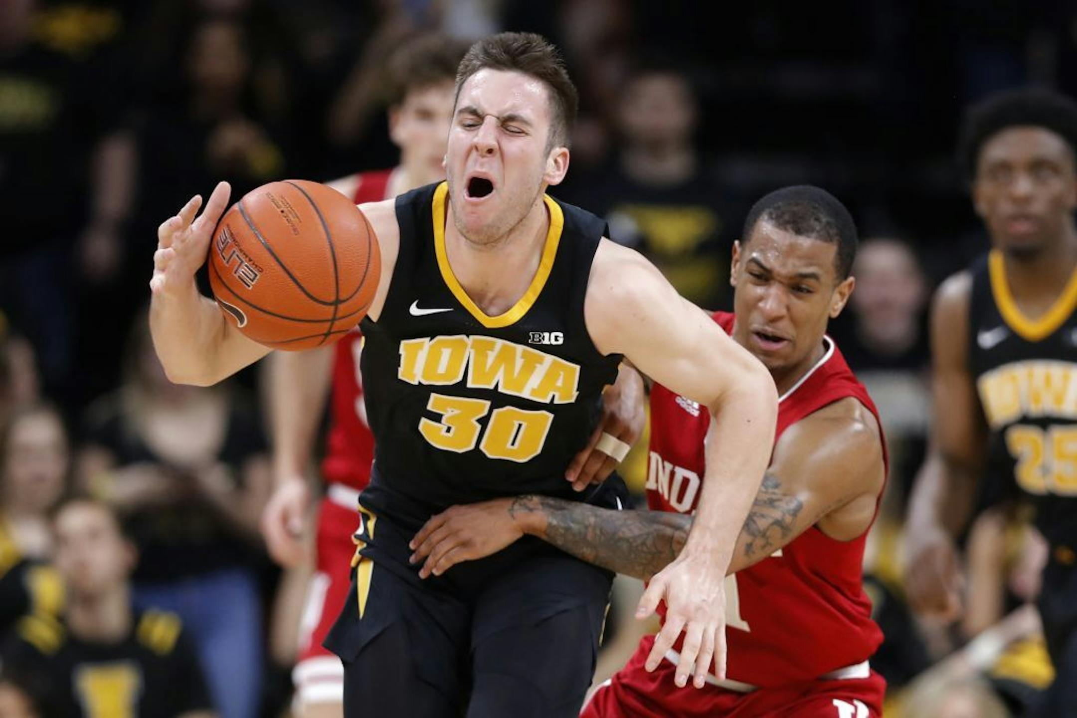 Iowa guard Connor McCaffery is fouled by Indiana guard Devonte Green, right, during the second half of an NCAA college basketball game Friday, Feb. 22, 2019, in Iowa City, Iowa.