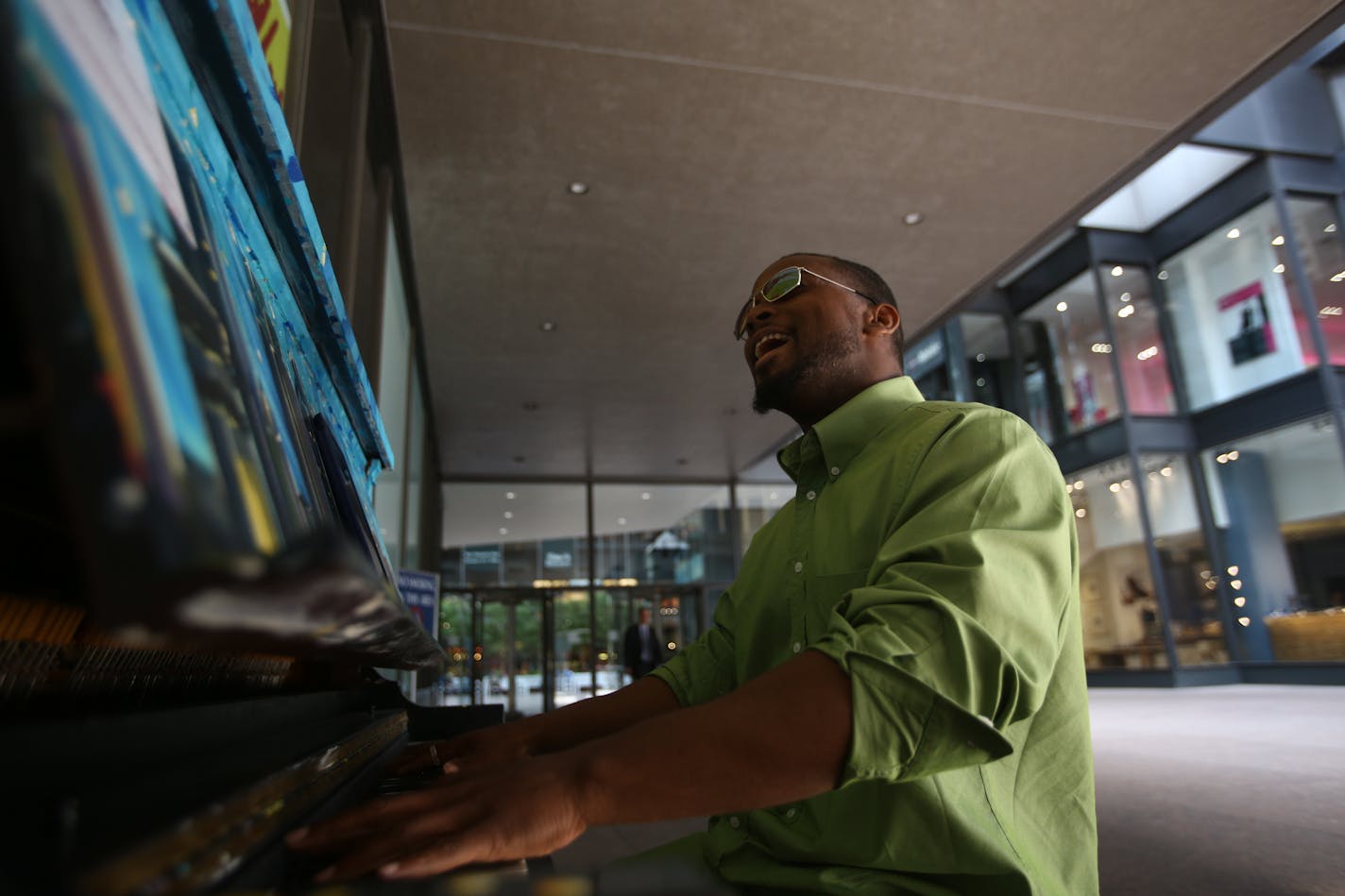 Walter Hampton of St. Paul plays a piano outside of the IDS Center on Wednesday.. The piano, painted by artist Sam Basques, is one of 25 uniquely designed pianos available throughout downtown Minneapolis during the month of June.