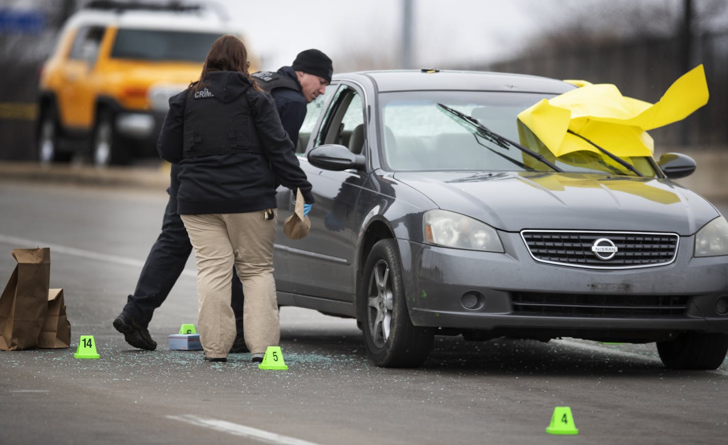 Members of the crime lab collected evidence from around the car where one man was shot to death and another wounded on N. 7th St. heading into downtown Minneapolis on March 31, 2019.