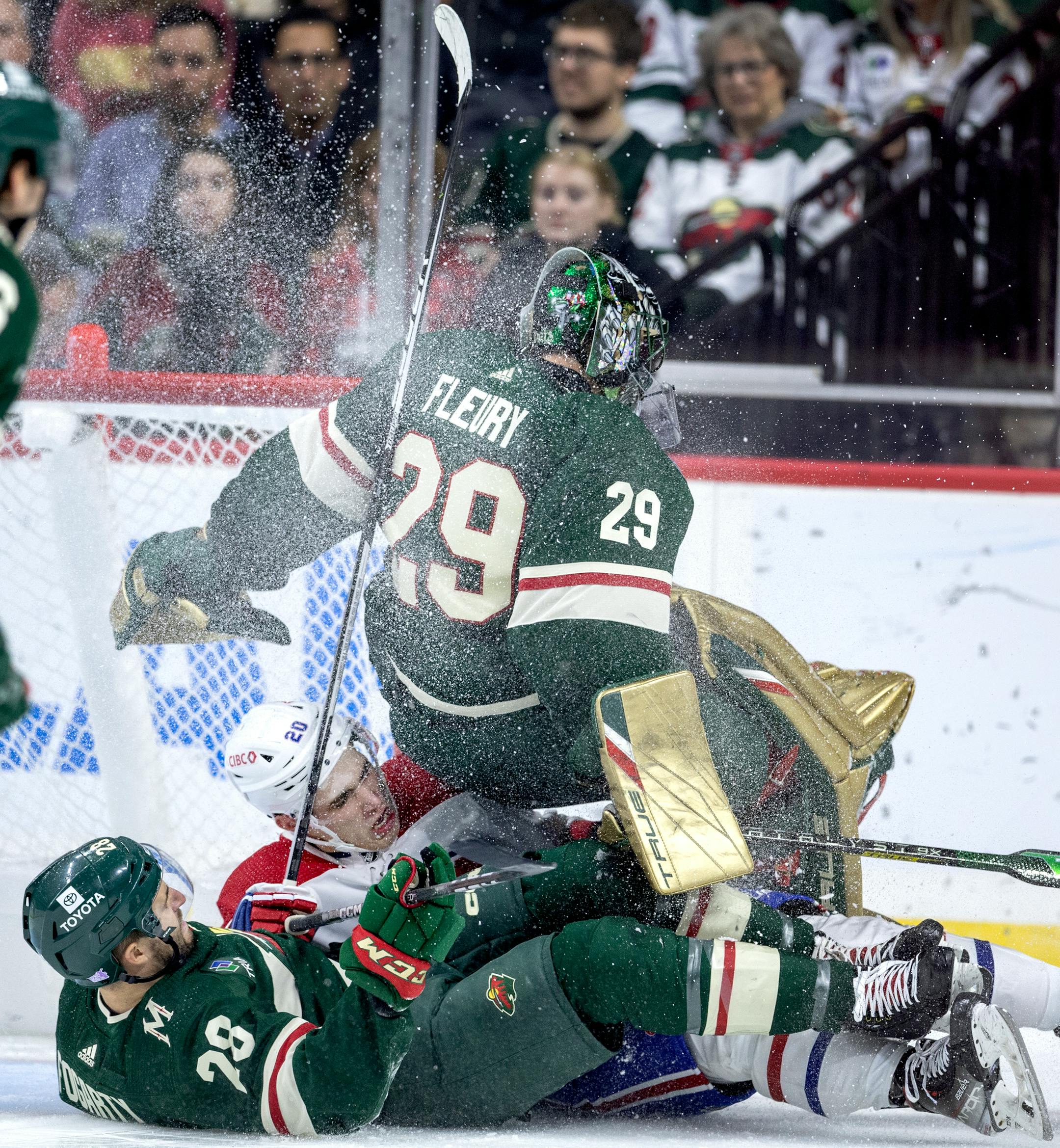 Steven Fogarty (28) and Marc Andre Fleury (29) of the Minnesota Wild get tangled with Juraj Slafkovsky (20 of the Montreal Canadiens in the second period.