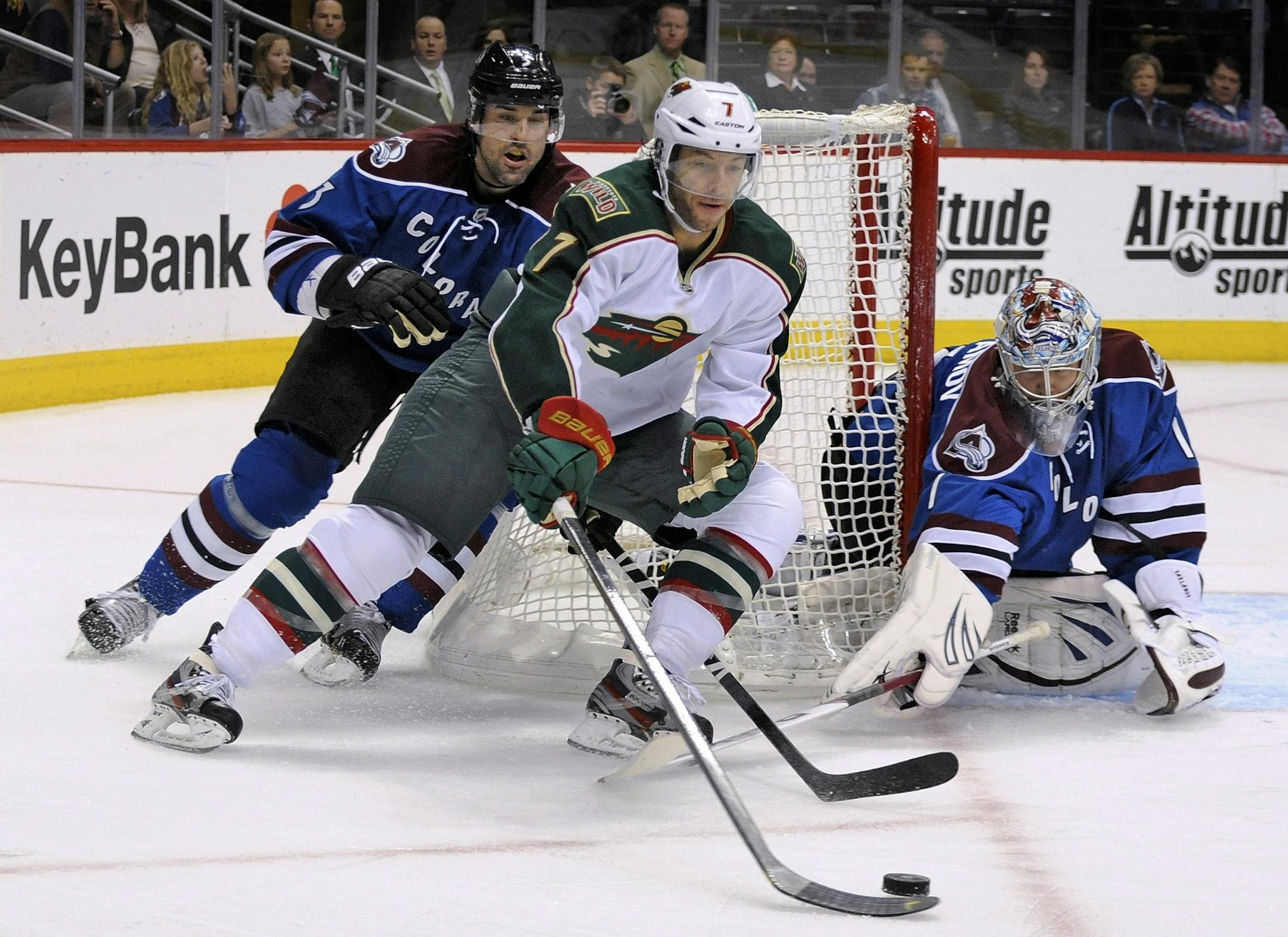 Minnesota Wild center Matt Cullen (7) moves the puck to the net as Colorado Avalanche defenseman Ryan O'Byrne (3) and goalie Semyon Varlamov (1), from Russia, defend during the second period of an NHL hockey game on Saturday, March 16, 2013, in Denver.
