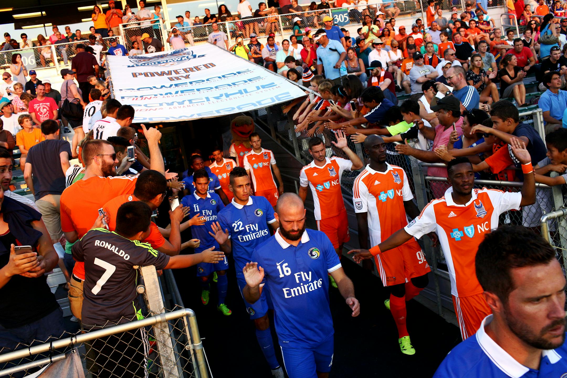 Members of the Carolina RailHawks and the New York Cosmos take the field for a match in Cary, N.C., Aug. 22, 2015.