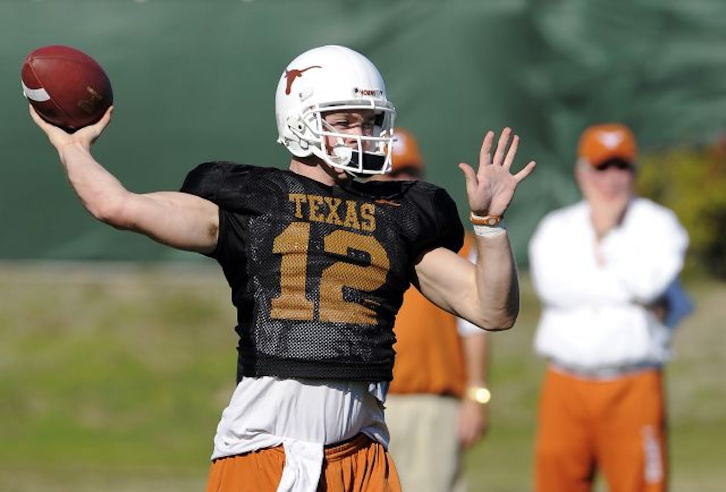 Texas quarterback Colt McCoy (12) throws as head coach Mack Brown looks on during practice, Saturday, Jan. 2, 2010, in Newport Beach, Calif., for their BCS Championship NCAA college football game against Alabama. The game is scheduled for Thursday, Jan. 7.