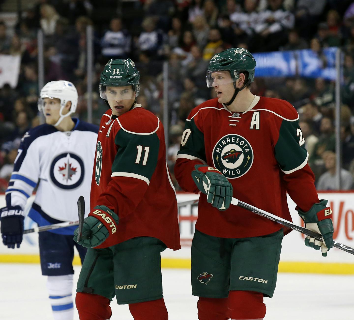 Minnesota Wild left wing Zach Parise (11) talks with defenseman Ryan Suter (20) during the second period of an NHL hockey game against the Winnipeg Jets in St. Paul, Minn., Friday, Nov. 27, 2015. (AP Photo/Ann Heisenfelt)