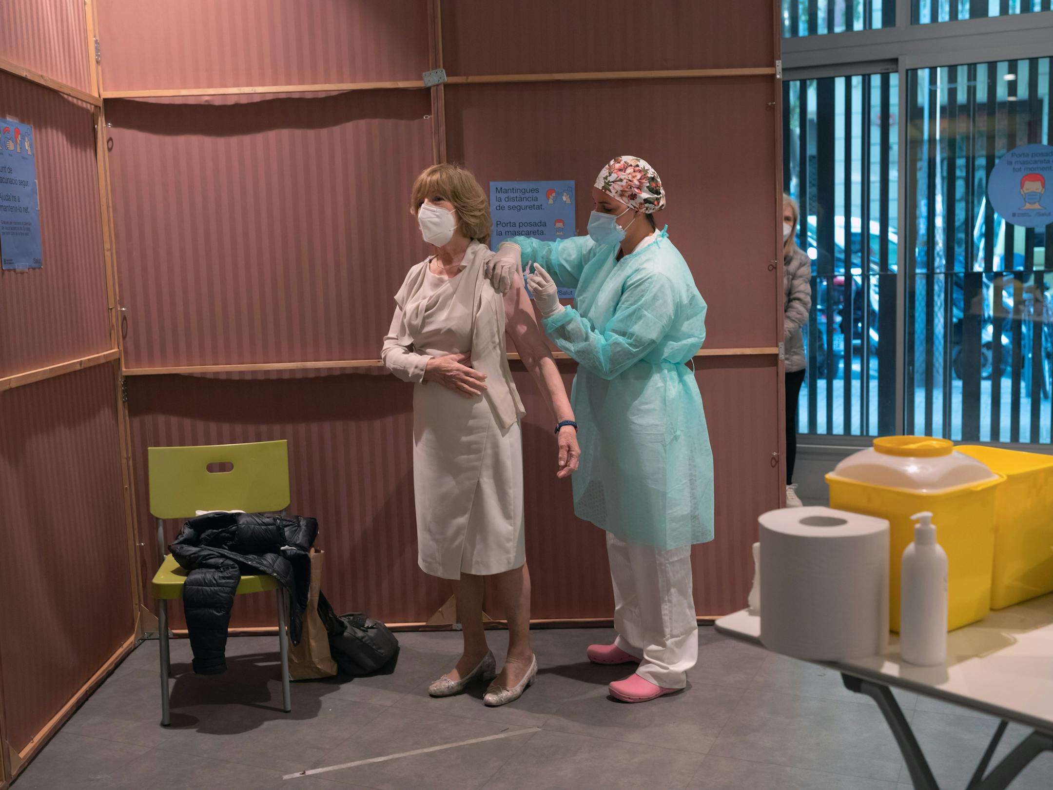 A woman is vaccinated for the seasonal flu in Barcelona, Spain, Oct. 16, 2020. A raft of lawsuits has emerged from a health care system where the struggle to fight the pandemic has led to neglect of other serious conditions.