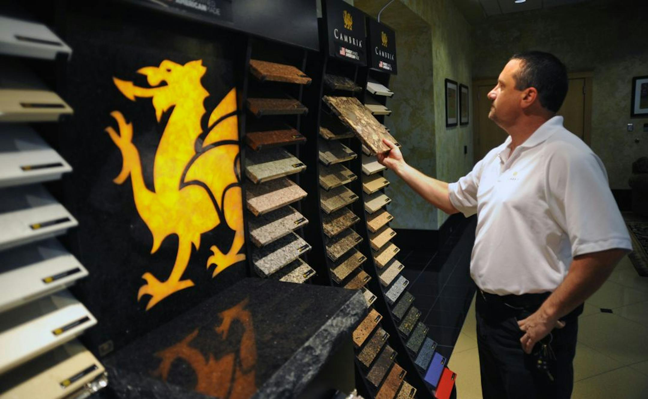 Plant manager Butch Brey looked over some samples in the company showroom. The Minnesota quartz countertop company is so busy that it has back orders on some designs.