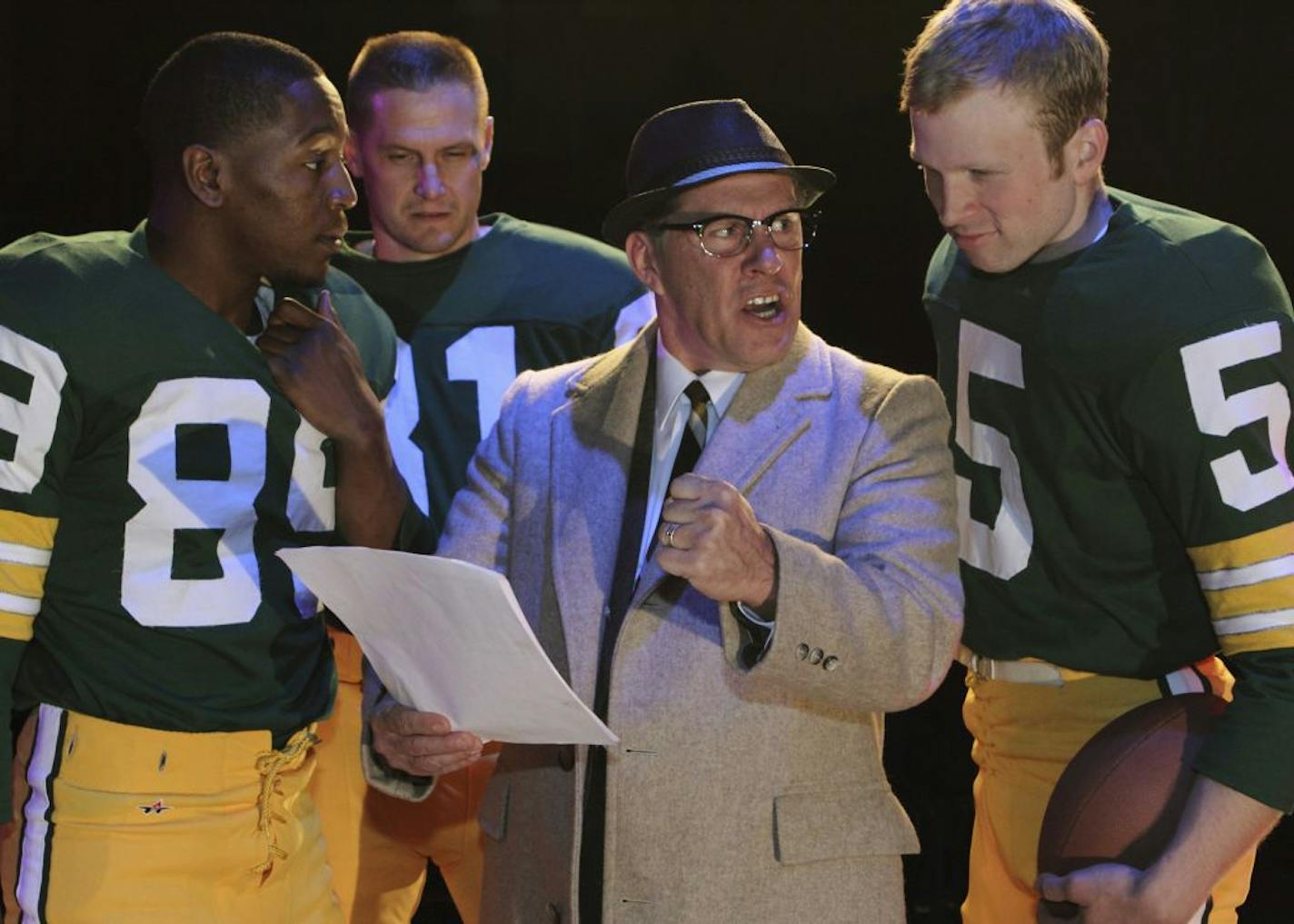 Coach Vince Lombardi (Jim Detmar) shows Dave Robinson (Darius Dotch), Jim Taylor (Eric Knutson), and Paul Hornung (Sam Bardwell) the next offensive play in History Theatre's upcoming production of LOMBARDI. Photo by Scott Pakudaitis.