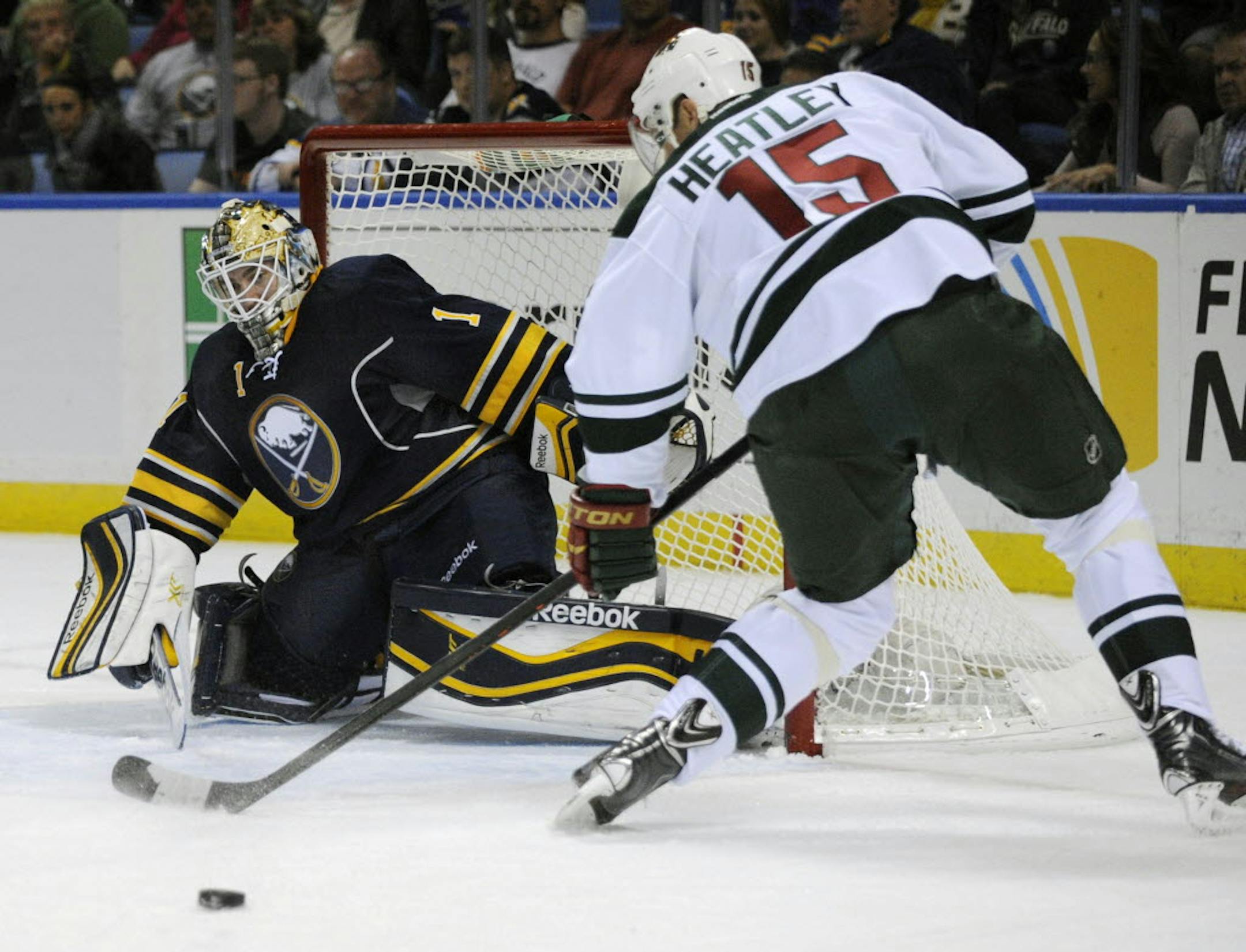 Buffalo goaltender Jhonas Enroth slides across the goal crease while Minnesota left winger Dany Heatley shoots the puck during the second period of Monday night's game.