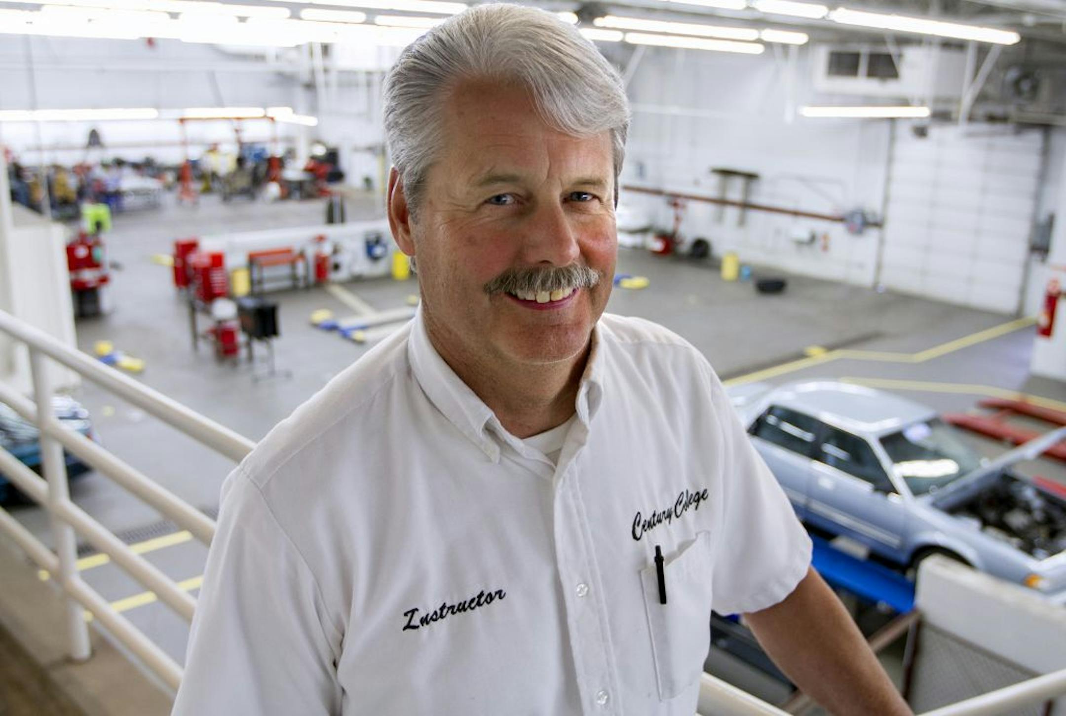 Tom Chall (cq/source) in the auto shop at Century College. Chall said he's been teaching there since before they laid the concrete.
