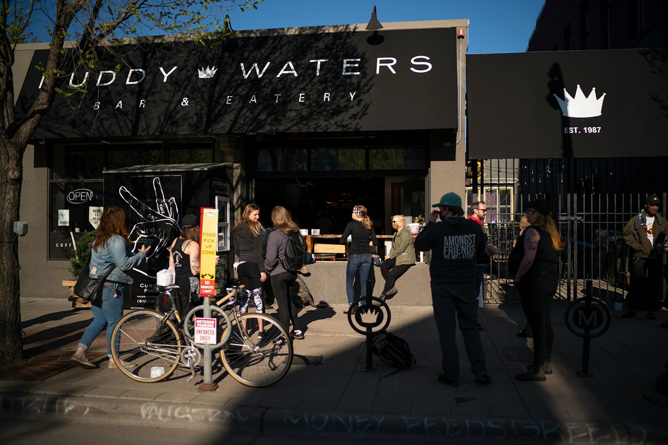 Customers and former employees gathered on the sidewalk outside Muddy Waters Sunday evening to say their farewells. It was an emotional scene at Muddy Waters early Sunday afternoon, May 3, 2020 as loyal customers and former employees mingled on the last day of service at the beloved bar and restaurant in the Lyn-Lake area.