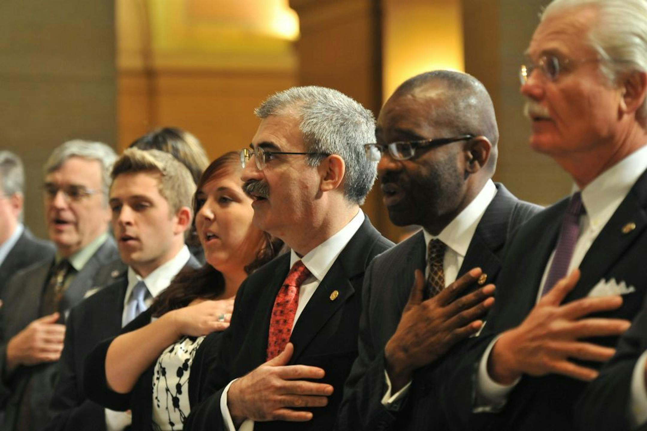 MnSCU Chancellor Steven Rosenstone, center said the Pledge of Allegiance before his installation ceremony Wednesday, October 19, 2011, in the State Capitol Rotunda.